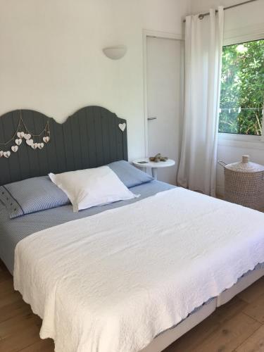 une chambre avec un grand lit et une fenêtre dans l'établissement Le Cabanon Cap d Antibes 80 m de la plage, à Antibes