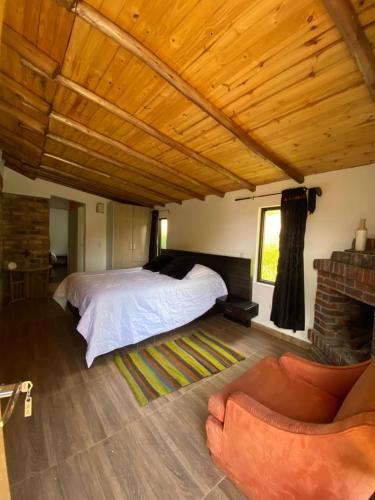 a bedroom with a bed and a couch in a room at Cabaña Media Luna in Guatavita