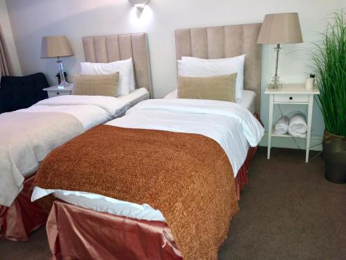 Duas camas sentadas uma ao lado da outra num quarto em Contemporary large apartment in an ideal location em Bath