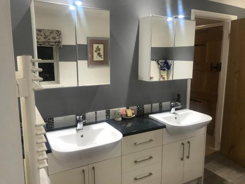 a bathroom with two sinks and a mirror at The Master Suite, enjoy the countryside in style in Ashover