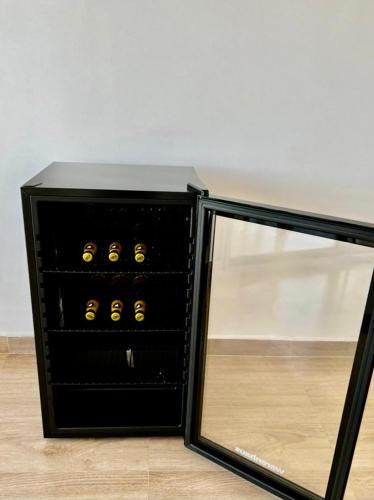 un estante de vino negro con botellas de vino amarillas en Sumaq House offer a new suite, en Puerto Ayora