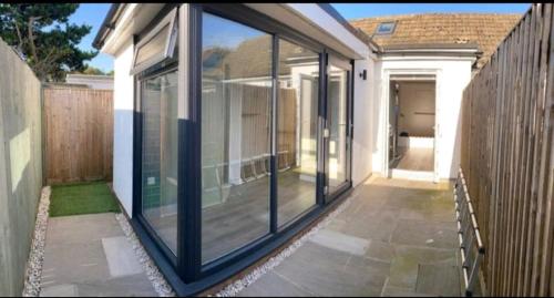 a screened in porch of a house with sliding glass doors at The Salty Bee in South Hayling