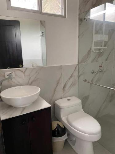 y baño con aseo blanco y lavamanos. en Sumaq House offer a new suite, en Puerto Ayora