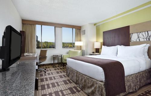 um quarto de hotel com uma cama grande e uma televisão de ecrã plano em Hotel Silver Spring em Silver Spring