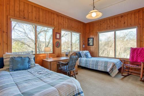 een slaapkamer met 2 bedden, een bureau en 2 ramen bij Lakeview on the Links in Waynesville