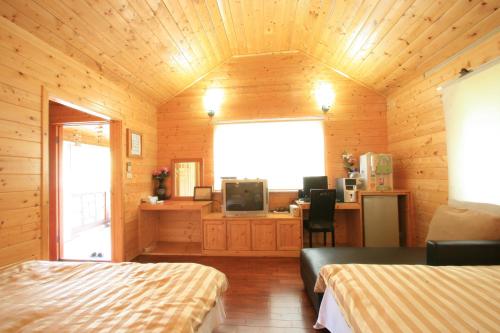 una habitación con 2 camas y un escritorio en una cabaña en Ji Ji Farm Homestay, en Jiji