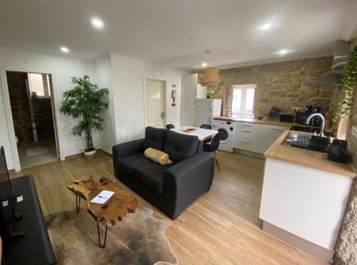 a living room with a couch and a kitchen at Cantinho D'Aldeia in Guarda