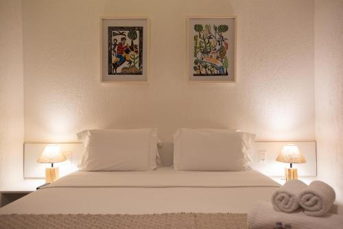 a bedroom with a white bed with two towels on it at Pousada da Germana in Fernando de Noronha