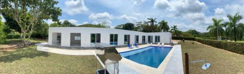 a house with a swimming pool in front of it at Casa Blanca Girardot Melgar in Girardot