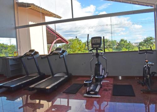 a gym with two treadmills and a camera at diRoma Fiori - Apartamentos JN in Caldas Novas