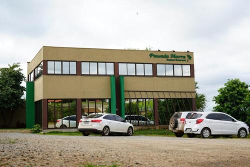 two cars parked in front of a building at Hotel Pousada Marra in Catalão