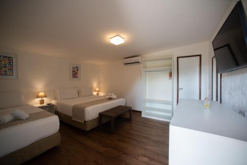 a hotel room with two beds and a television at Pousada da Germana in Fernando de Noronha