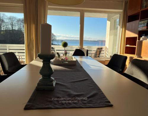 a candle on a table with a view of the ocean at Ferienwohnung Inselblick in Glücksburg