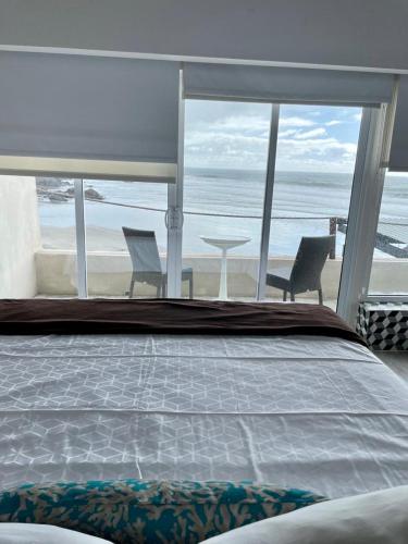 a bedroom with a bed and a view of the beach at Castillos Del Mar in Rosarito