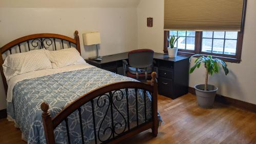 a bedroom with a bed and a desk with a plant at Beautiful and Cozy Homes in Cortland