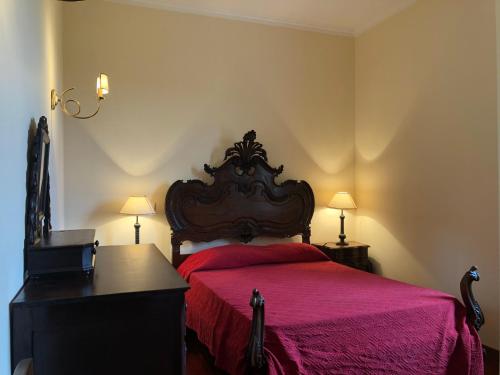 a bedroom with a bed with a red bedspread at Casa das Eiras in Tondela