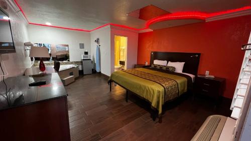 a bedroom with a bed and a red wall at New American Inn & Suites in Anaheim