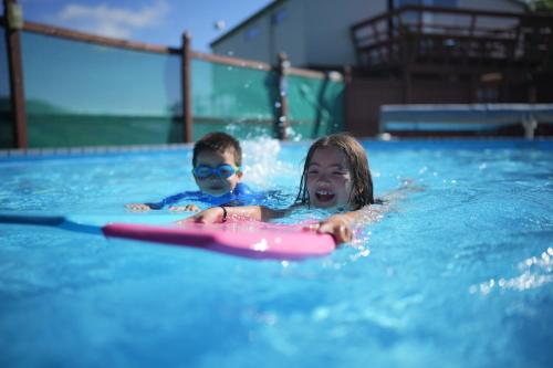 a boy and a girl swimming in a pool at Akaroa Top 10 Holiday Park in Akaroa