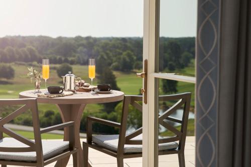 a table and two chairs with a table and a window at Keswick Hall in Charlottesville