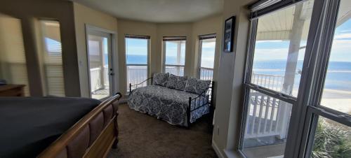 a bedroom with a bed and a chair and windows at Paradise by the Sea in Carrabelle
