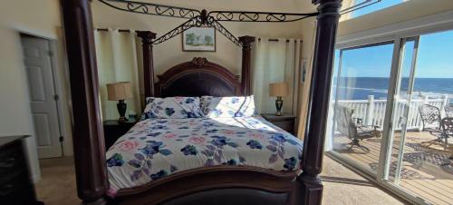 a bedroom with a canopy bed with a view of the ocean at Paradise by the Sea in Carrabelle