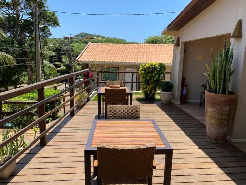 a wooden deck with a table and chairs on it at Pousada da Germana in Fernando de Noronha