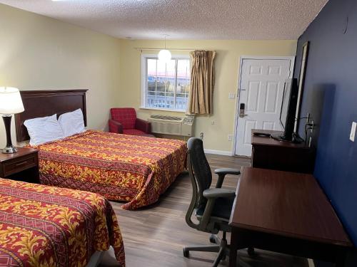 a hotel room with two beds and a desk at Royal Lodge in Absecon