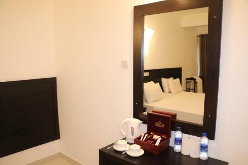 een hotelkamer met een bed en een spiegel bij Tangalle Rest House in Tangalle