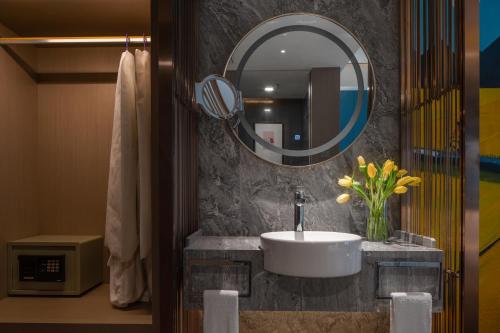 a bathroom with a sink and a mirror at Chengdu Tianfu Sunshine Hotel in Chengdu