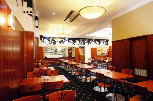 a dining room with tables and chairs in a restaurant at Great Southern Hotel Sydney in Sydney