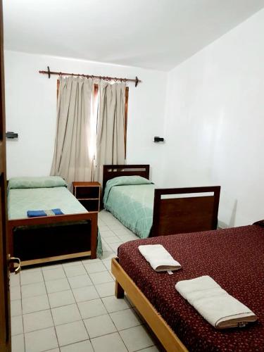 a bedroom with two beds with towels on them at La Viñita in Cafayate