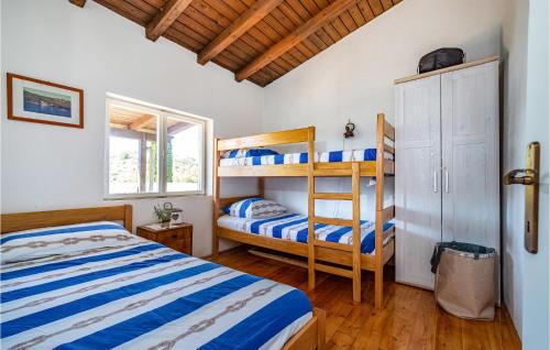 a bedroom with two bunk beds and a window at Nice Home In Sali With 2 Bedrooms And Wifi in Sali