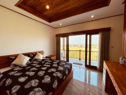 a bedroom with a large bed and a balcony at Surfers Villa and Resorts Medewi in Jembrana