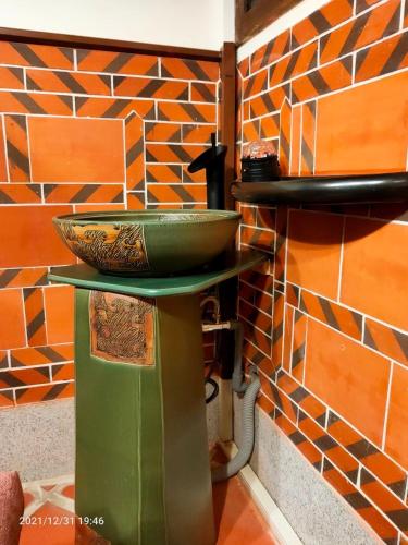 a bowl on a stand in front of a brick wall at 新龍頭古厝行館 Shin Long Tou B&B in Jinning