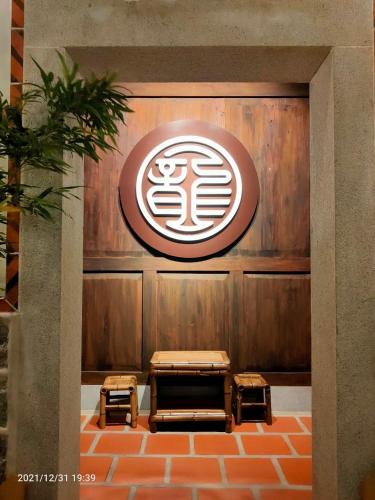 a restaurant with benches and a sign on the wall at 新龍頭古厝行館 Shin Long Tou B&B in Jinning