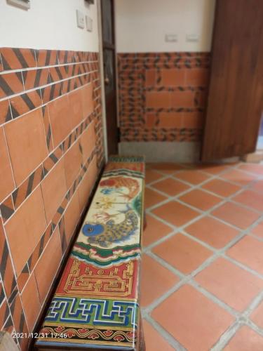a bench in the corner of a room with tiles at 新龍頭古厝行館 Shin Long Tou B&B in Jinning