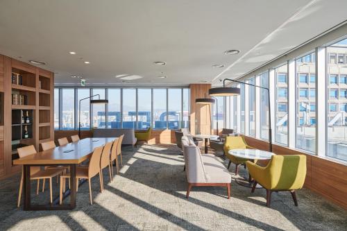 a dining room with tables and chairs and windows at Nine Tree by Parnas Seoul Myeongdong 2 in Seoul