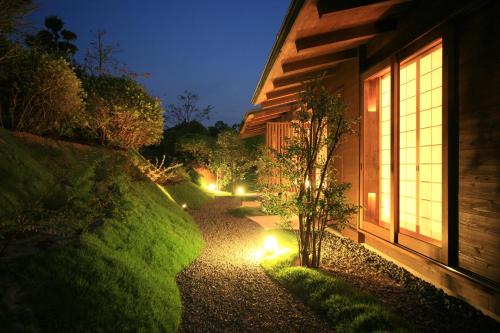 a garden path leading to a house at night at Satsuki Bessou in Tamana