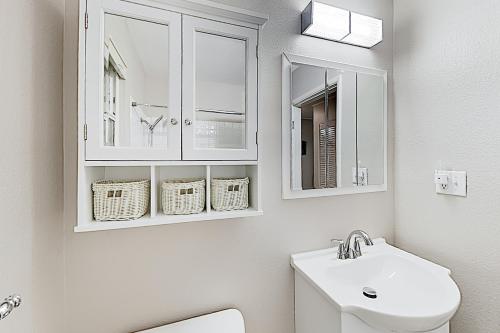 a white bathroom with a sink and a mirror at Sunsets over Sound in Des Moines