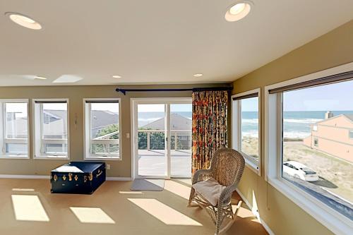 a living room with large windows and the ocean at Big Retreat in Neskowin