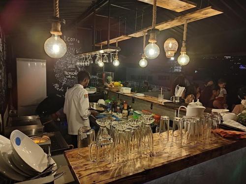 a chef standing in a kitchen with glasses on a counter at Dumbara Peak Residence in Kandy