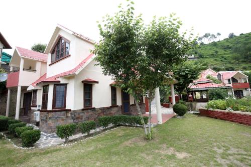 a house with a tree in the yard at Manla Homes Resort in Mashobra