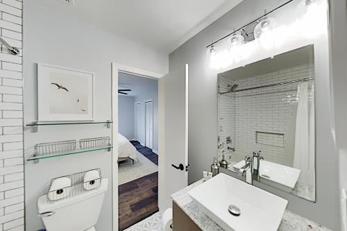 a white bathroom with a sink and a mirror at Hunter's Terrace in Charleston
