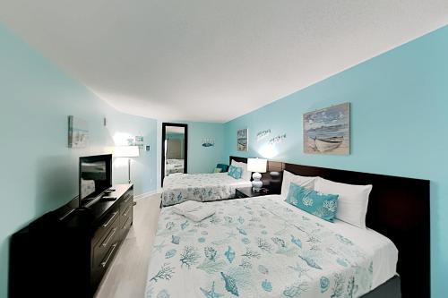 a bedroom with two beds and a flat screen tv at Oceans One Resort Unit 403 in Myrtle Beach