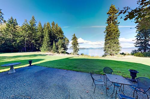 un patio con mesa y sillas junto a un lago en Bay to Baker, en Oak Harbor