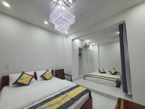 a bedroom with two beds and a chandelier at Song Anh Hotel in Buon Ma Thuot