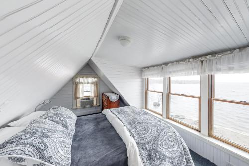 a attic bedroom with two beds and a window at Dream Harbor House and Cottage in Surry