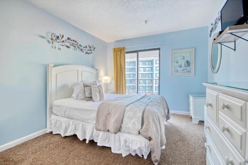 a bedroom with a white bed and a window at Renaissance 211 in Myrtle Beach