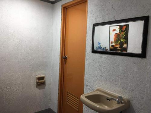 Pinoykano home في Candijay: حمام مع حوض وصورة على الحائط