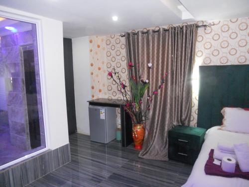 a room with a bed and a vase with flowers in it at Gold Crown International Hotel With Complementary Breakfast and WiFi in Johannesburg
